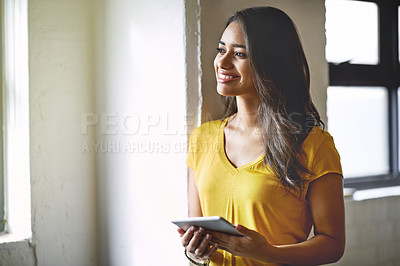 Buy stock photo Shot of a young designer looking thoughtful while holding her digital tablet