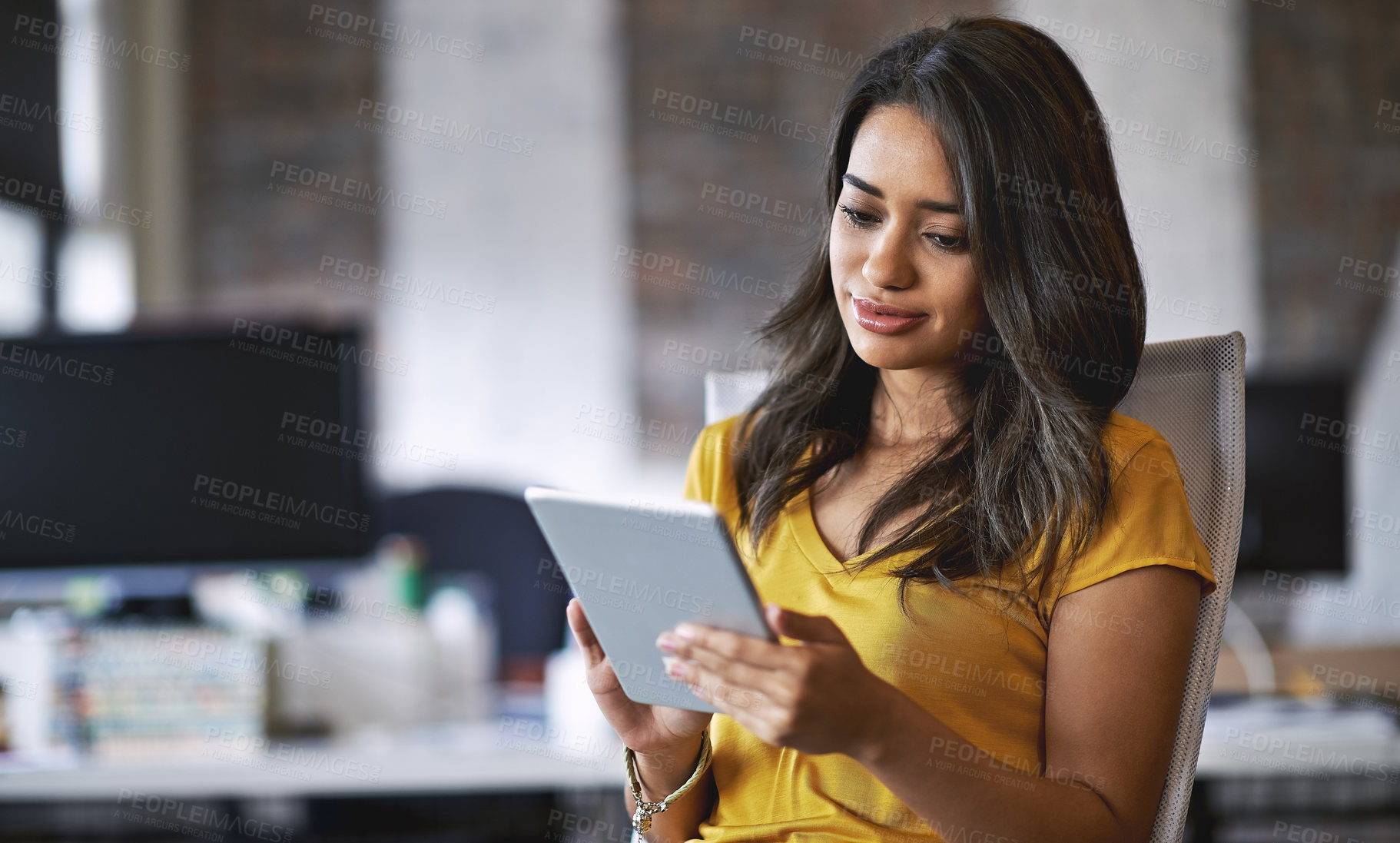 Buy stock photo Shot of a young designer working on a digital tablet in an office