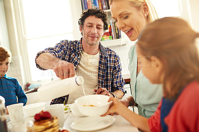 Buy stock photo Family, breakfast and happiness in house for eating, joy and kids at table in morning for nutrition. Dad, mom and children indoors for weekend fun, wellness and milk in kitchen for cereal meal