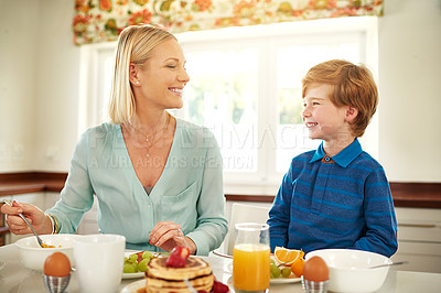 Buy stock photo Mother, son and breakfast in house kitchen for eating, pancakes and nutrition with plate, knife and fork. Woman, kid and brunch in home at morning for hungry, coffee and health with fruit by table