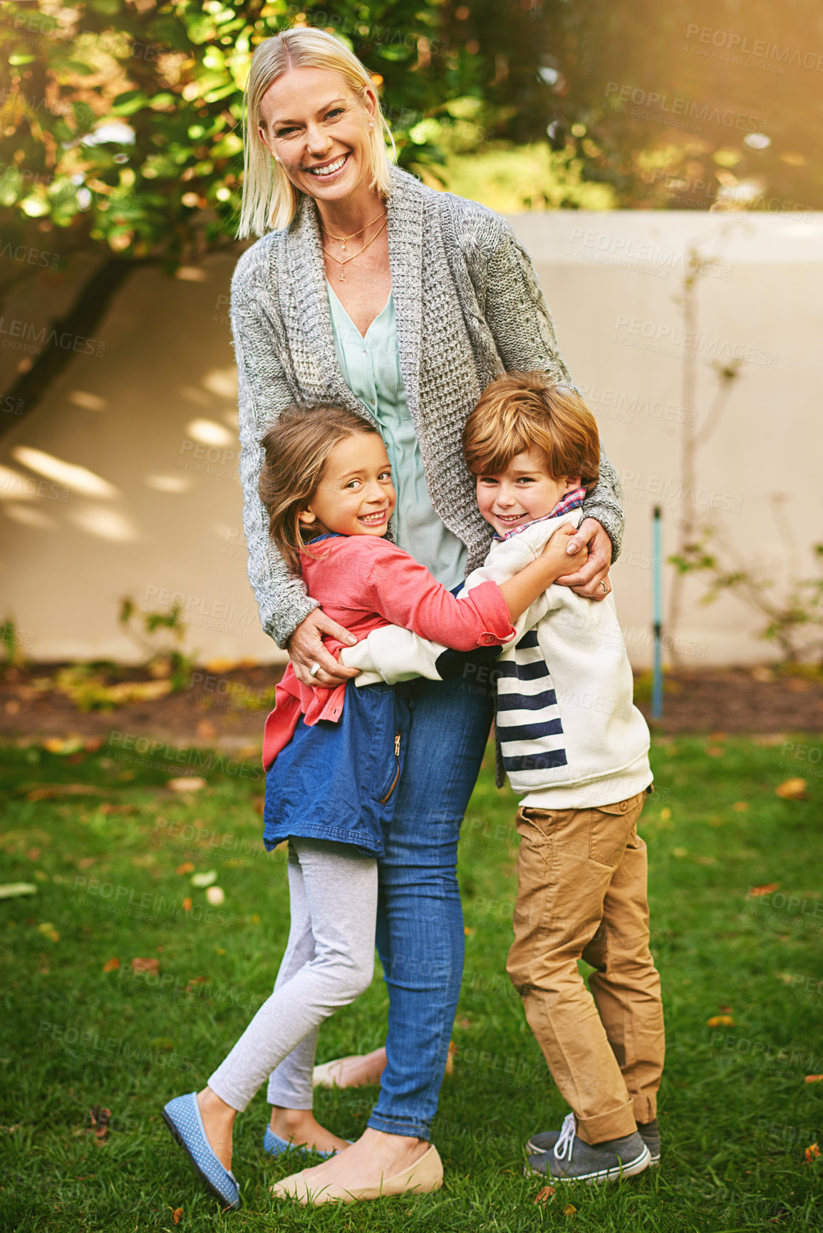 Buy stock photo Portrait of two adorable siblings hugging their mother outside
