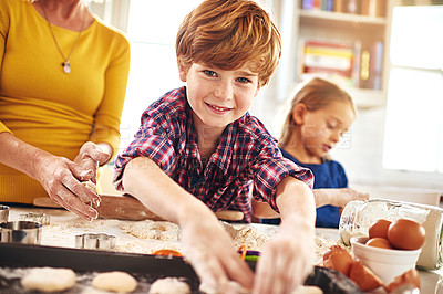 Buy stock photo Portrait of a young boy baking together with his family at home