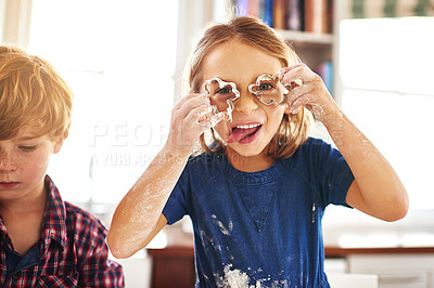 Buy stock photo Girl, cookie cutter and funny face in kitchen with sibling for baking, learning and fun for childhood on holiday indoor. Young child, happy and portrait for silly and playful enjoyment with brother 