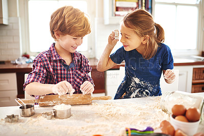 Buy stock photo Cropped shot of two young children having fun while baking together at home