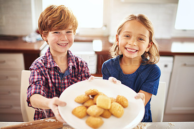 Buy stock photo Portrait of two young children holding a plate of biscuits together