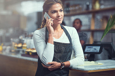 Buy stock photo Shot of a young woman using a phone in the store that she works at