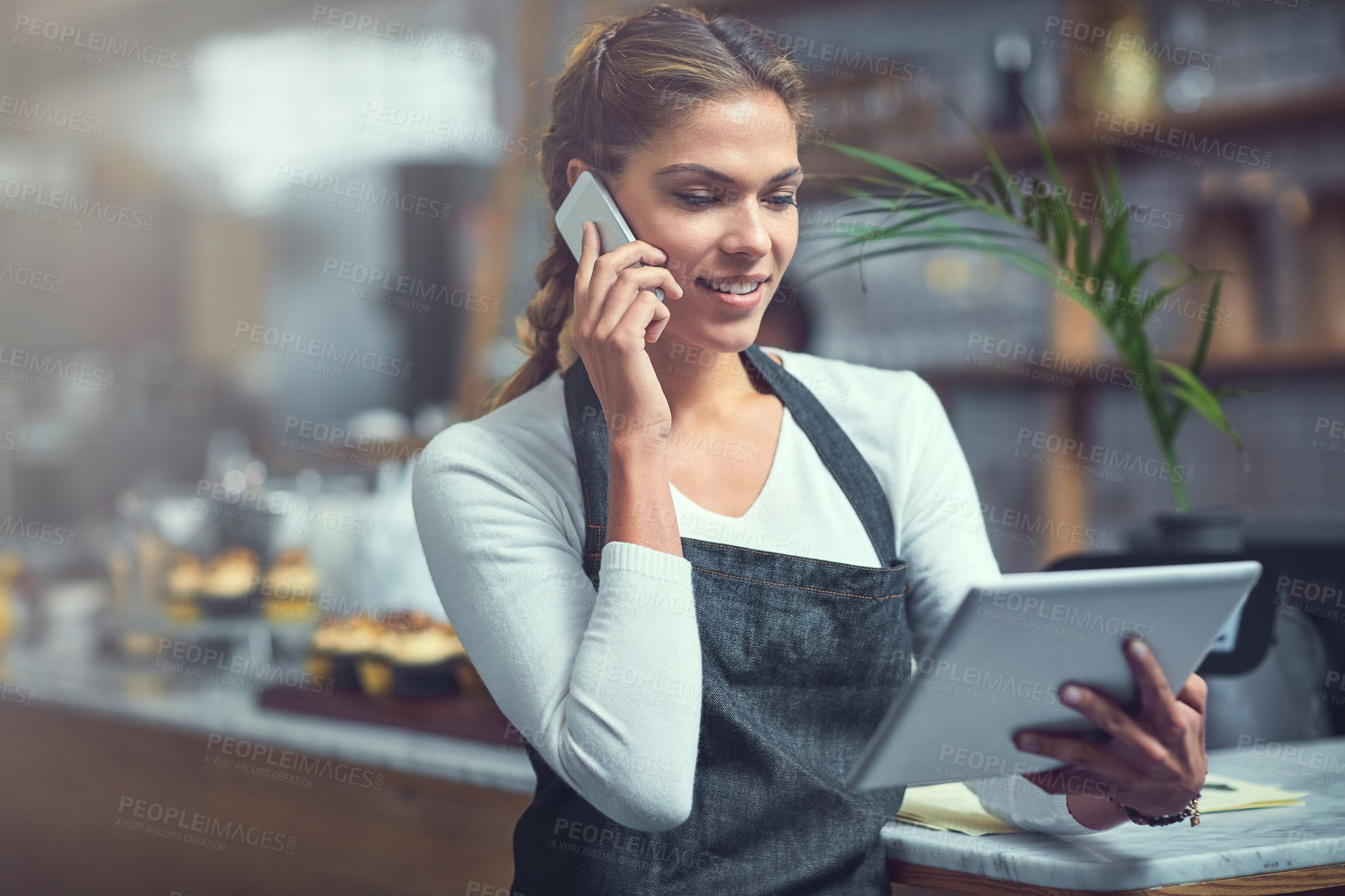 Buy stock photo Small business, woman and tablet in coffee shop with phone call, communication and stock order. Cafe owner, smile or feedback with tech for customer service, inventory management and supplier contact