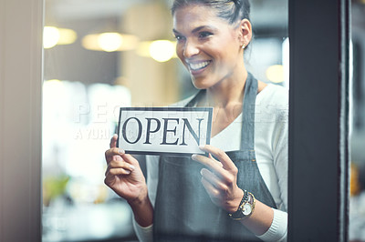 Buy stock photo Shot of a young woman hanging an open sign on the door of her store