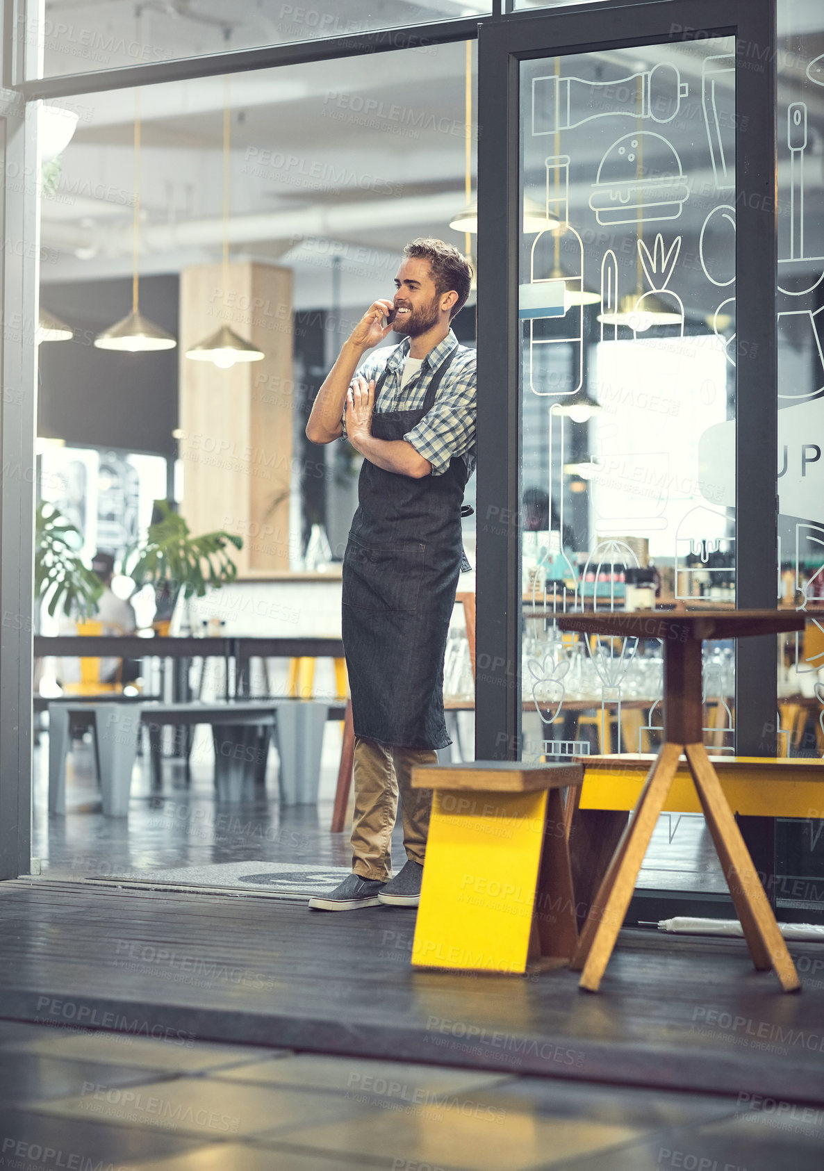 Buy stock photo Shot of a young man using a phone in the store that he works at