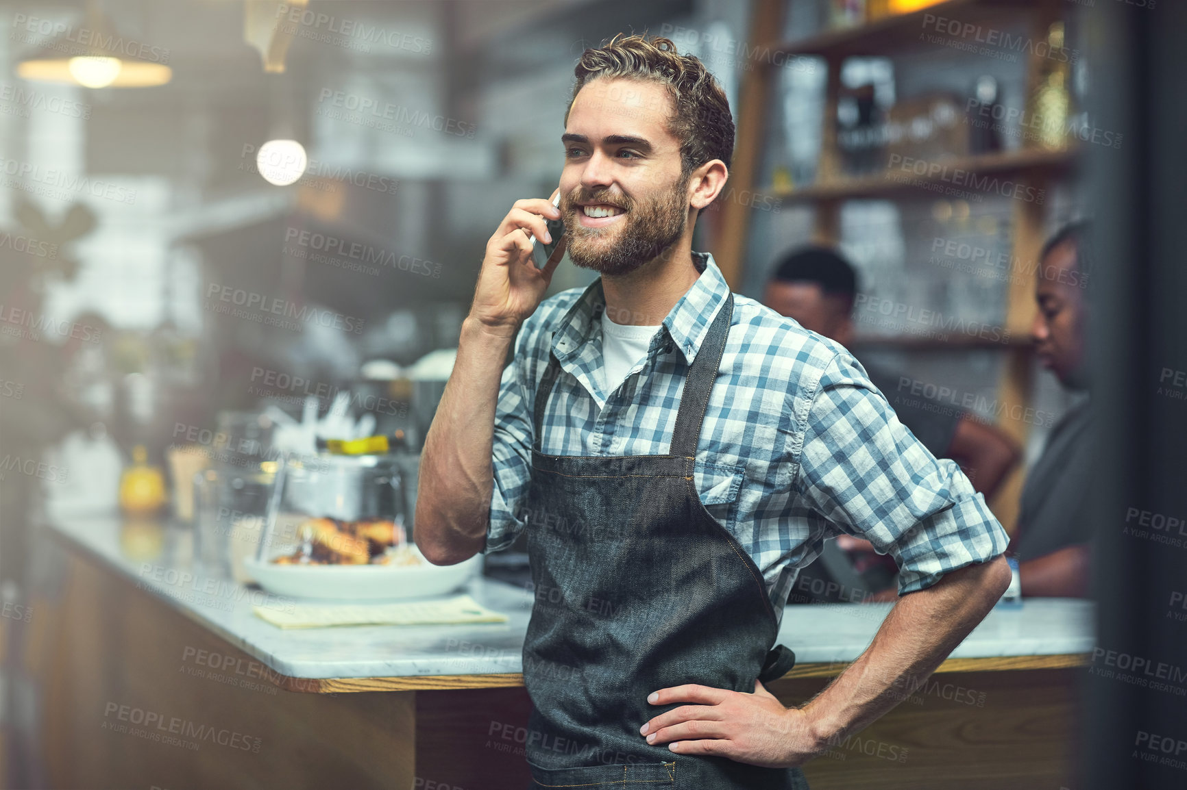 Buy stock photo Shot of a young man using a phone in the store that he works at