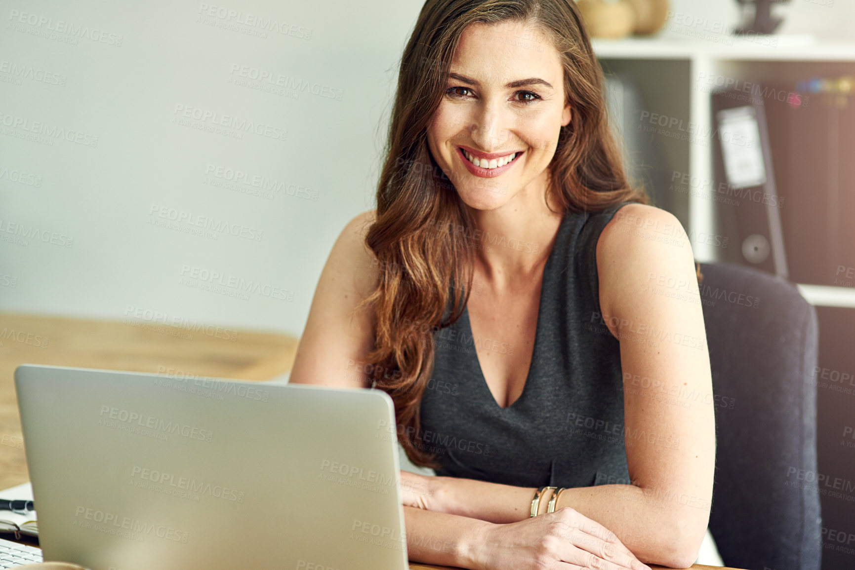 Buy stock photo Portrait of a young businesswoman working on a laptop in a modern office