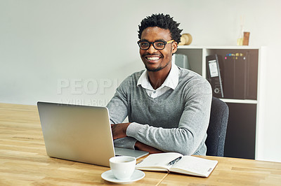 Buy stock photo Portrait of a young businessman working on a laptop in a modern office
