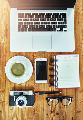 Buy stock photo Cropped shot of a creative businessperson's desk with a laptop, camera, smartphone and other objects