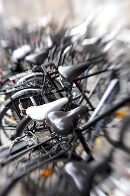 Buy stock photo Blurred shot of a bicycles at a bicycle rack in a city