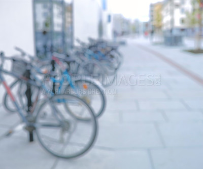 Buy stock photo Bicycle, parking rack and outdoor with row for eco friendly travel, security or sustainability with blur. Bike, street and urban sidewalk with transportation, carbon footprint and mobility in Spain