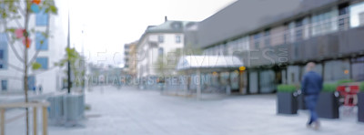 Buy stock photo Person, walking and urban with blurry outdoor for travel destination, city explore and buildings on street. Architecture, gloomy weather and road for infrastructure journey, downtown trip and commute