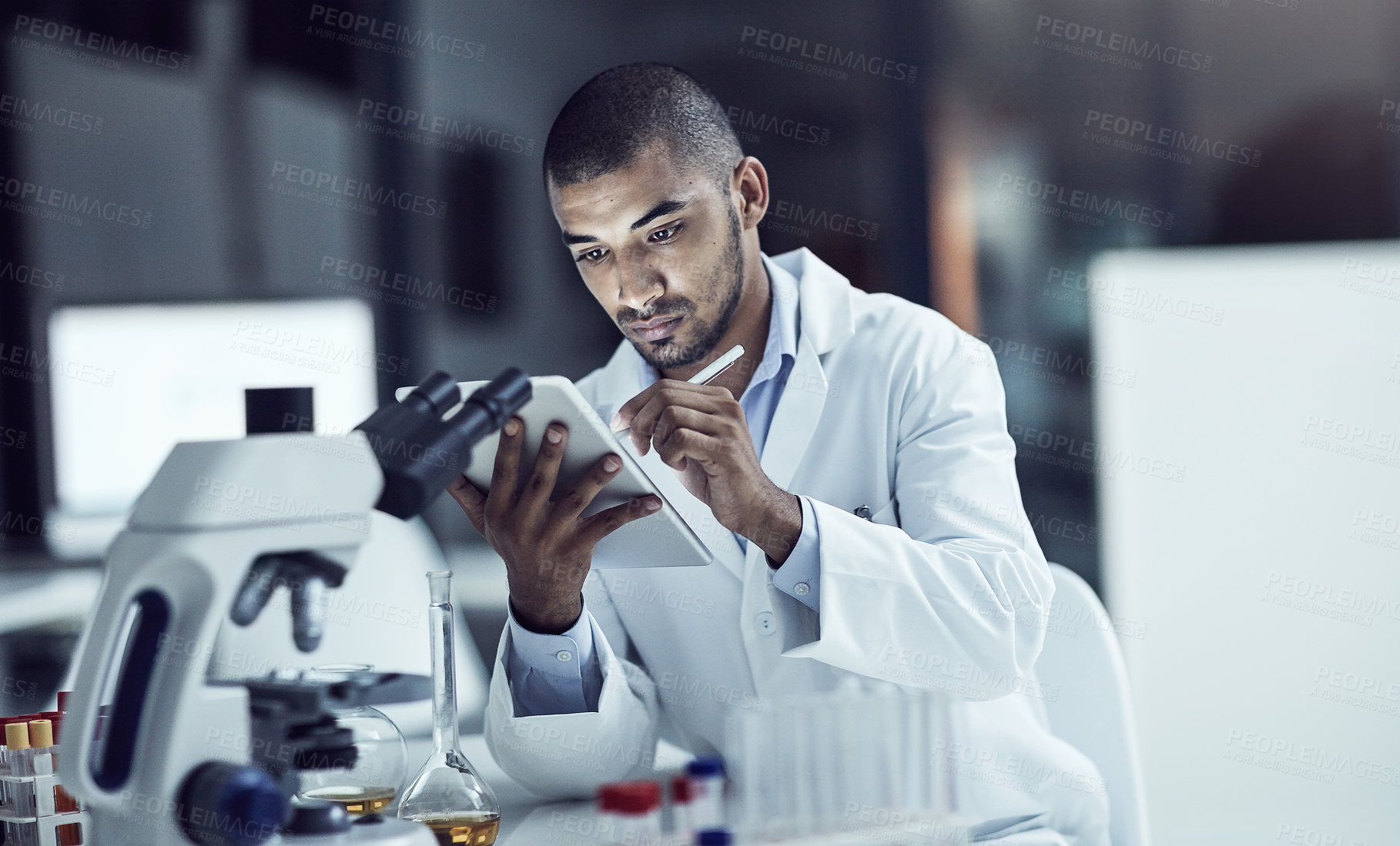 Buy stock photo Shot of a scientist recording his findings on a digital tablet