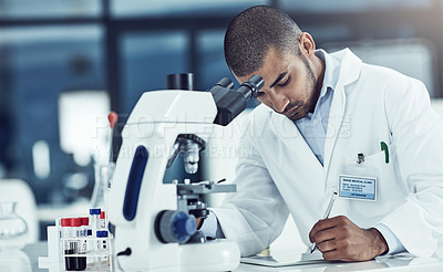 Buy stock photo Focused male lab technician using digital tablet working on medical development and innovation project with microscope, taking notes. Doctor diagnosing test tube blood sample with science equipment.
