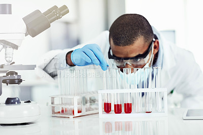 Buy stock photo Smart looking scientist working with blood sample, DNA testing or virus research in a lab. Black male science or biology expert analyzing test tube for disease or medical innovation in a laboratory
