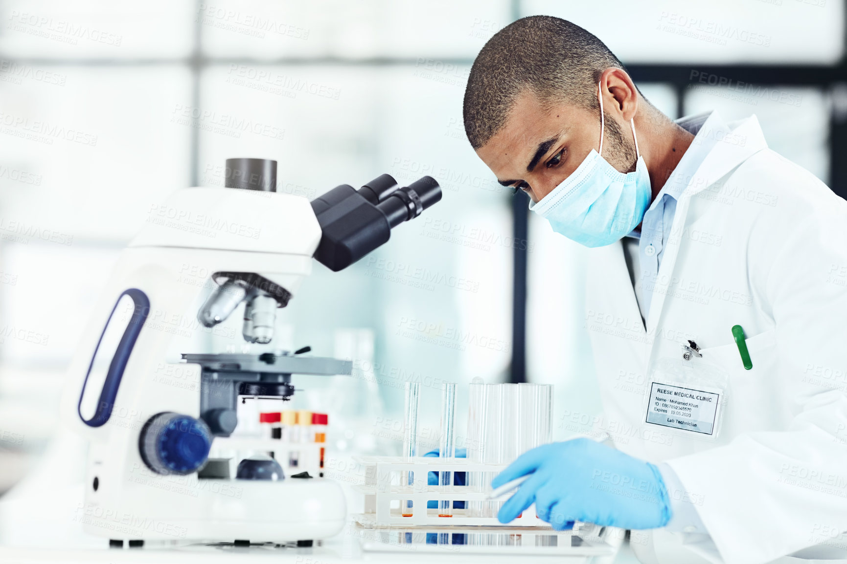 Buy stock photo Cropped shot of a young male scientist working in his lab