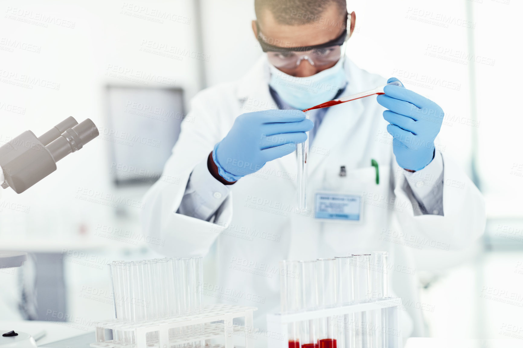 Buy stock photo A scientist conducting an experiment on a covid vaccine in a lab mixing chemicals in a test tube. A medical researcher working in a laboratory testing samples for a coronavirus research project