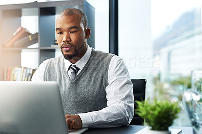 Buy stock photo Cropped shot of a young businessman working on his laptop in the office