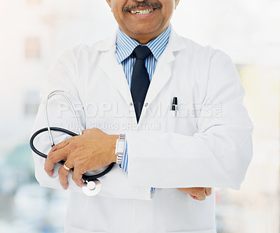 Buy stock photo Cropped shot of a doctor holding a stethoscope and folding his arms