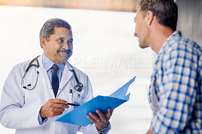 Buy stock photo Shot of a mature doctor giving his patient feedback during a consult