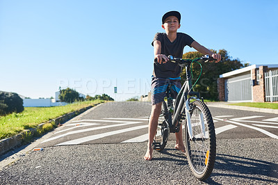 Buy stock photo Full length portrait of a young boy riding his bike outside
