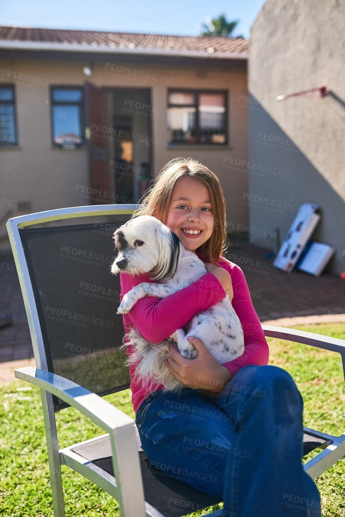 Buy stock photo Portrait of a happy little girl sitting on a chair and holding her pet dog outdoors
