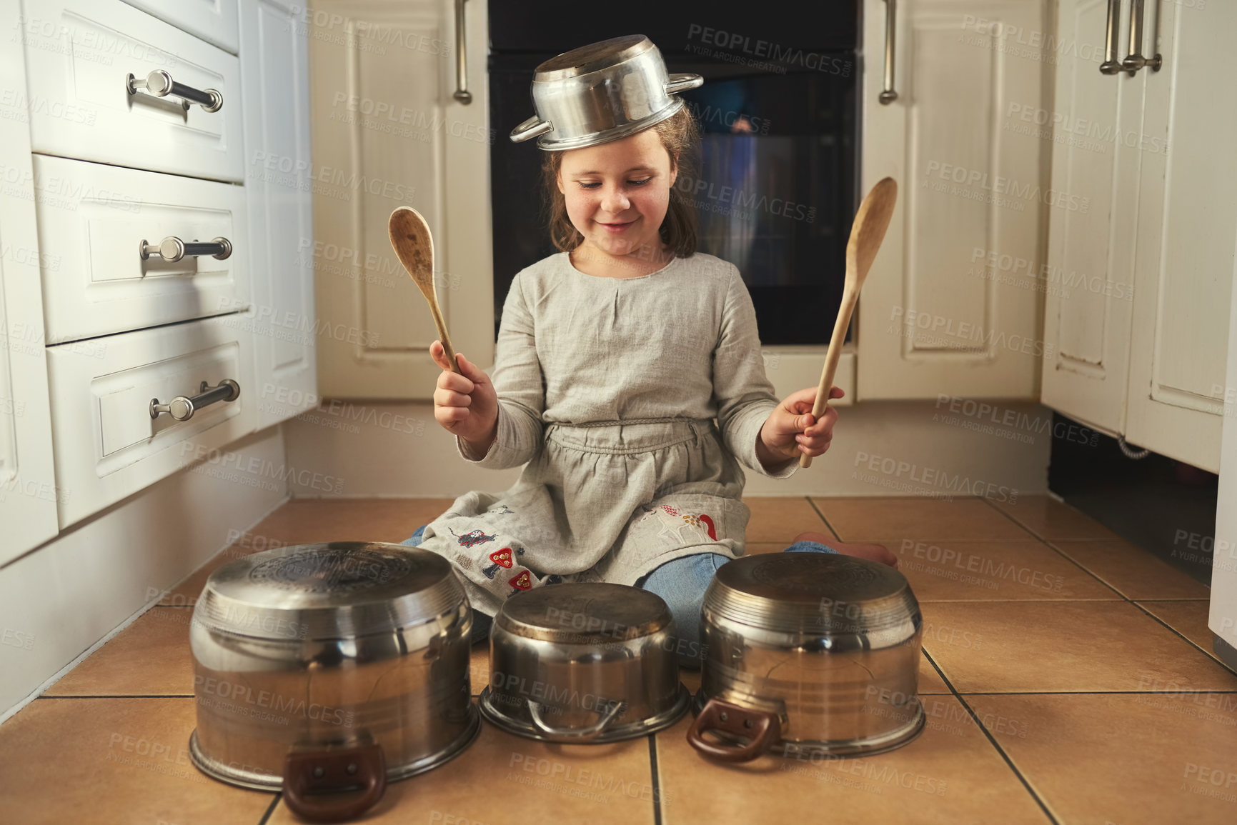 Buy stock photo Kitchen, pots and child drums with music, instrument and creative home on holiday or vacation. Kid, drummer and development of musician with noise, sound and girl playing concert on floor in house