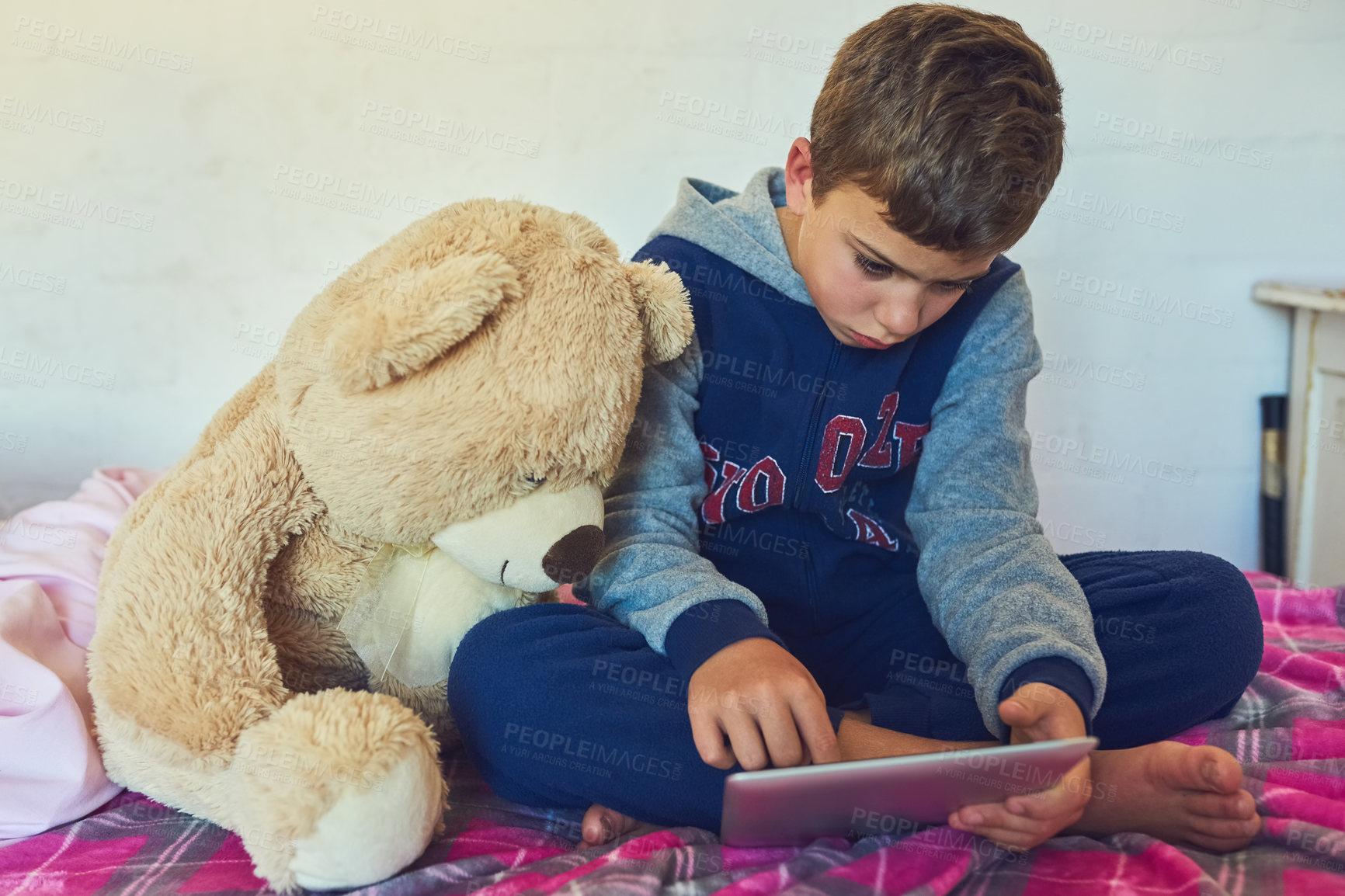 Buy stock photo Child, tablet and relax in home bedroom on holiday with education games, app and growth. Online, reading and kid watch a movie with teddy bear on bed streaming cartoon, movies or film on website