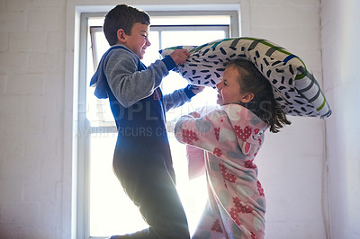 Buy stock photo Cropped shot of two young siblings pillow fighting at home