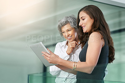 Buy stock photo Cropped shot of colleagues working together on a digital tablet in a modern office