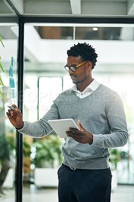 Buy stock photo Cropped shot of a young businessman writing notes on a glass wall in a modern office