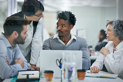 Buy stock photo Cropped shot of a group of colleagues brainstorming together on a laptop in a modern office