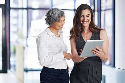 Buy stock photo Cropped shot of colleagues working together on a digital tablet in a modern office
