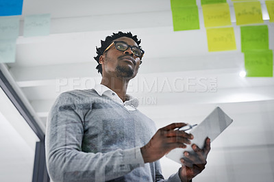 Buy stock photo Business tablet, glass wall and black man brainstorming, strategy or research ideas in office. Sticky notes, planning and African male professional with technology for working, schedule and low angle