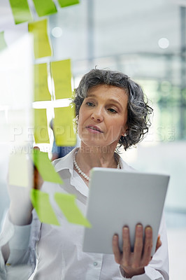 Buy stock photo Glass wall, tablet and business woman writing, planning and strategy in office workplace. Sticky notes, brainstorming and senior female professional with technology for working, schedule and info.