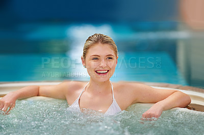 Buy stock photo Shot of a young woman relaxing in the jacuzzi at a spa