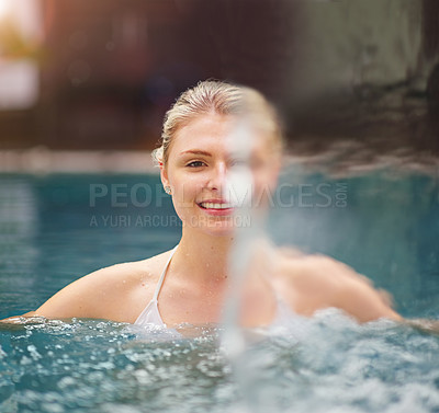 Buy stock photo Shot of a young woman relaxing in the jacuzzi at a spa