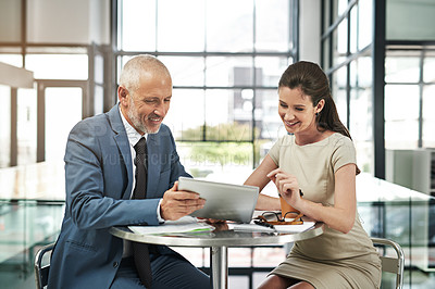 Buy stock photo Cropped shot of two businesspeople working together on a digital tablet in a modern office