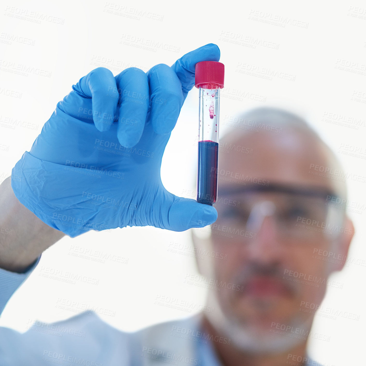 Buy stock photo Closeup shot of a male scientist examining a test tube in a lab