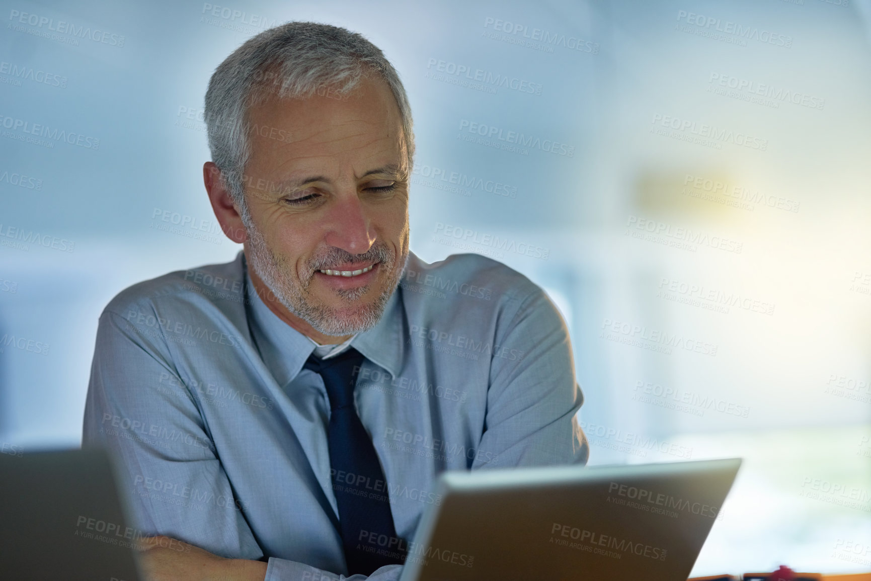 Buy stock photo Night, smile and tablet with business man at desk in office for administration, report or research. Internet, management and technology with mature boss or employee in workplace for information