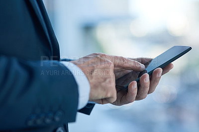 Buy stock photo Closeup shot of a businessman texting on a cellphone in an office