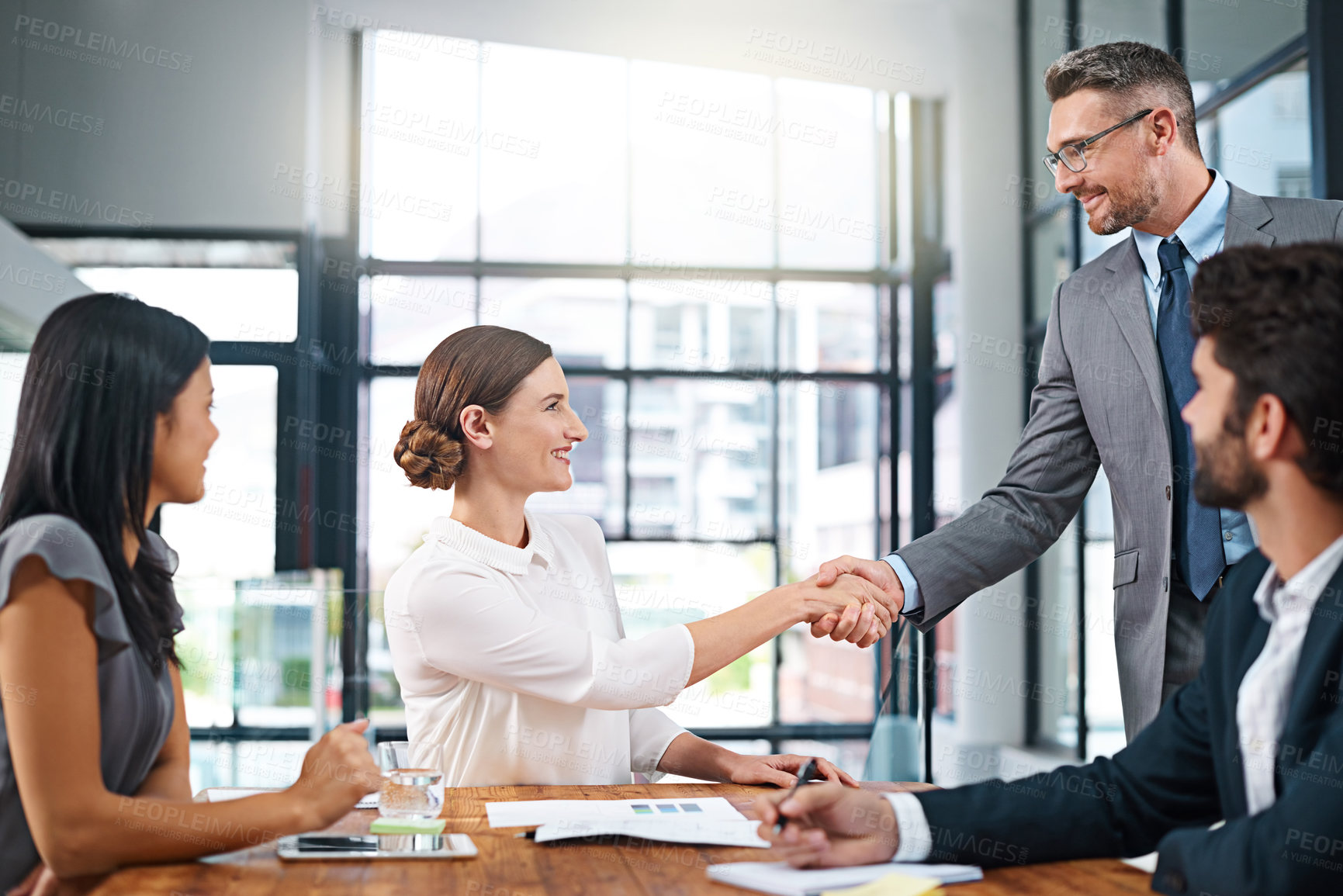 Buy stock photo Cropped shot of two businesspeople shaking hands during a meeting in the boardroom