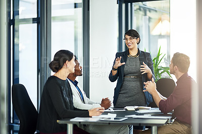 Buy stock photo Shot of a businesswoman delivering a presentation to her coworkers