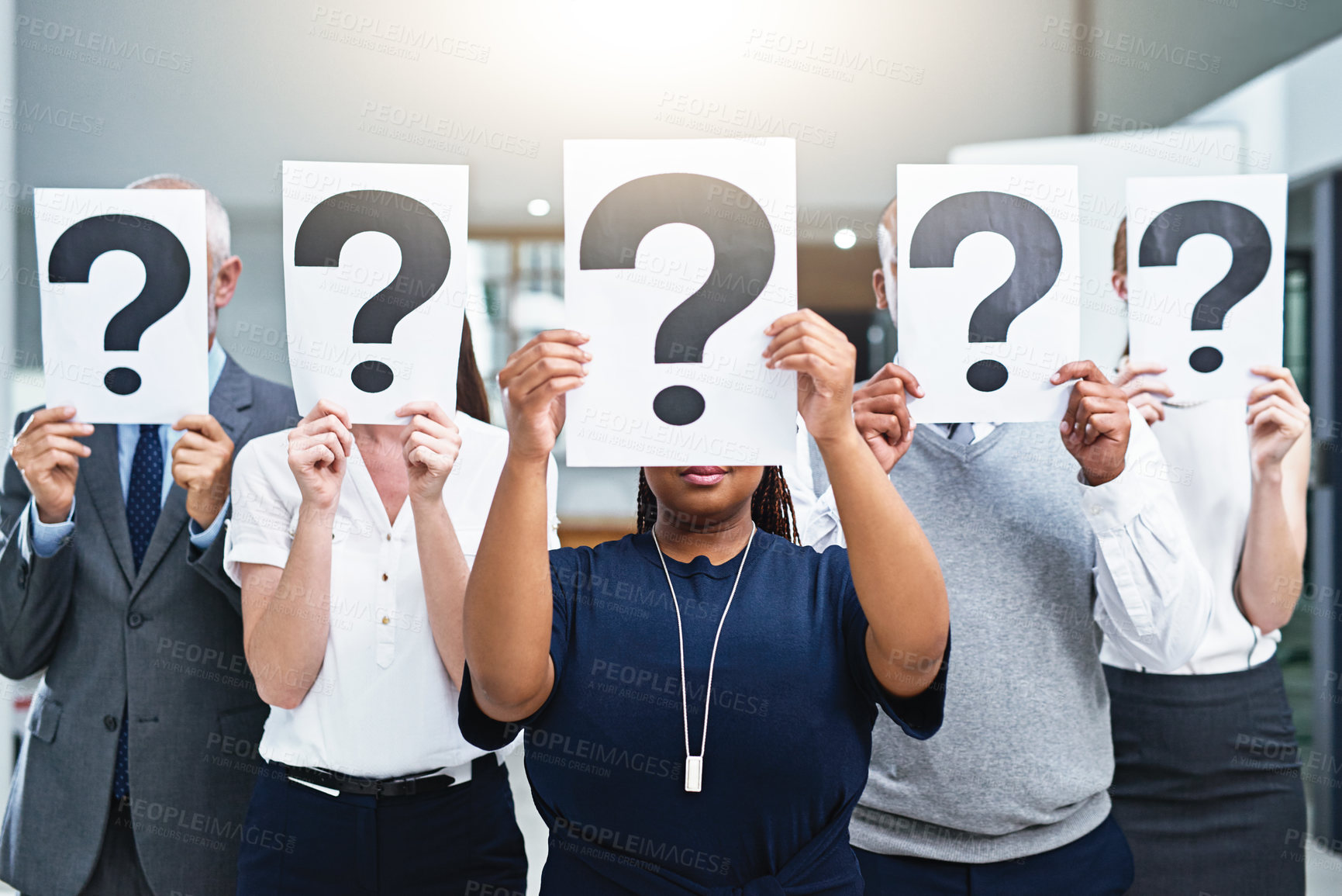 Buy stock photo Cropped shot of a group of businesspeople holding placards with question marks in front of their faces