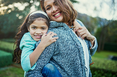 Buy stock photo Portrait of a happy mother and daughter enjoying a piggyback ride outdoors