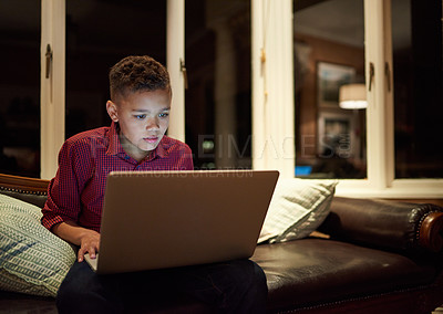 Buy stock photo Shot of a young boy using a laptop past his bedtime at home